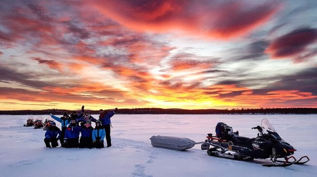 Bonito amanecer durante una excursión con moto de nieve en el lago Inari 