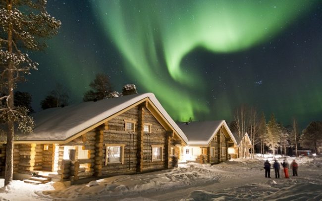 Cabañas de troncos bajo la Aurora Boreal 