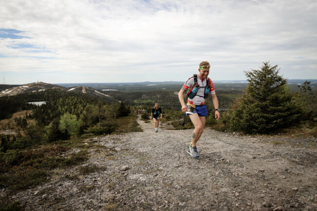 Corredores-durante-la-carrera-NUTS-en-Ruka-Al-fondo-la-estación-de-esquí_fotoVeeraVihervaara-VisitFinland