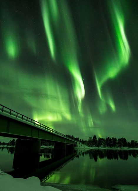 El puente sobre el río Paatsjoki en Nellim con la Aurora Boreal