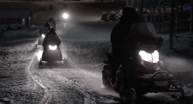 motos de nieve en excursión por la noche