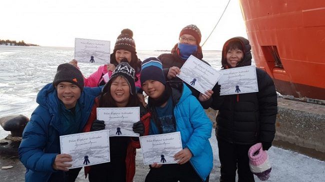 Grupo de turistas con el diploma de recuerdo de su visita 