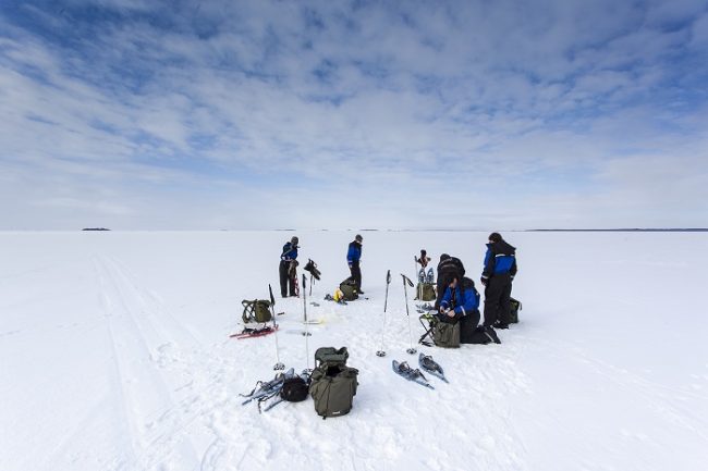 Grupo de turistas preparandose para pescar en el hielo en Laponia 