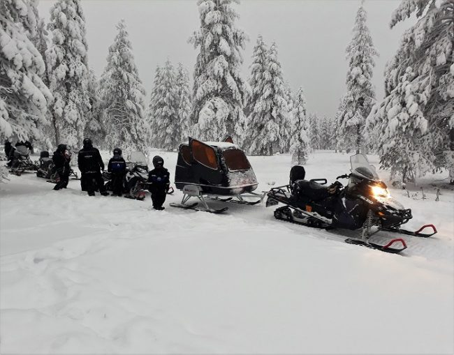 Safari con motos de nieve eléctricas. Los niños van en el trineo cubierto 