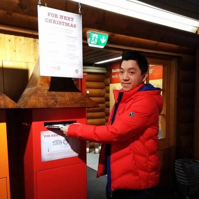 Un turista introduciendo sus postales en el buzón para la próxima Navidad 