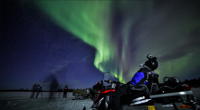 Disfrutando de la visión de la Aurora Boreal durante un safari con moto de nieve en Saariselkä 